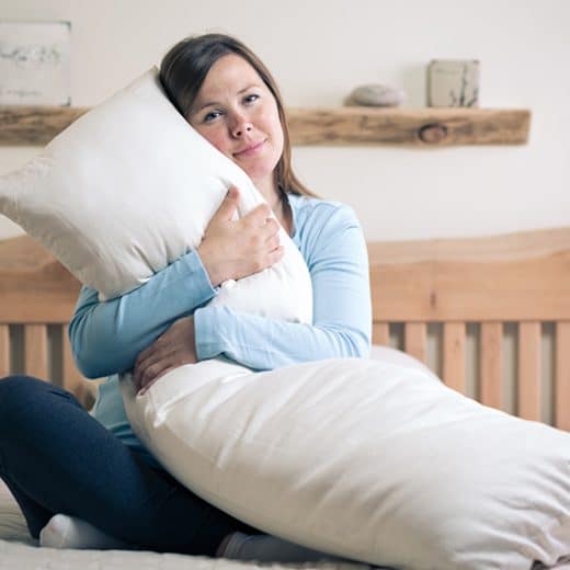 Organic Wool Body Pillow - woman hugging pillow in bed